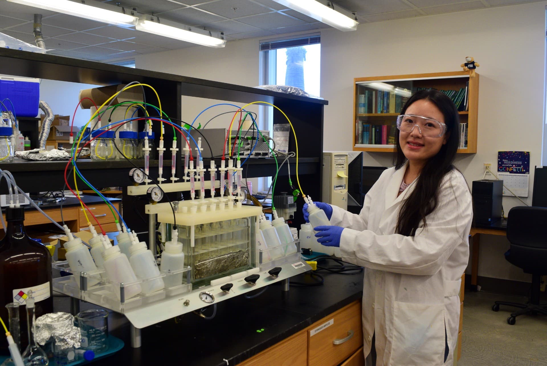 A researcher working with analytical equipment in a lab, focused on a monitor and machinery